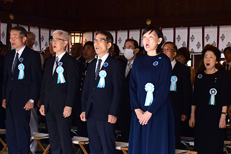 国歌を斉唱する参列者